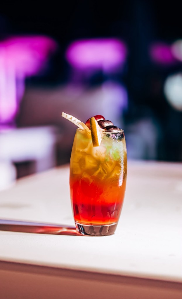 Layered cocktail with ice and fruit garnish